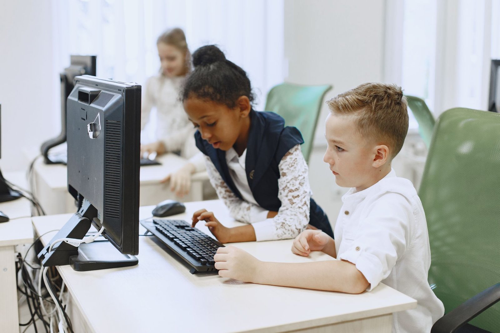 Enfants en cours de code dans une salle informatique